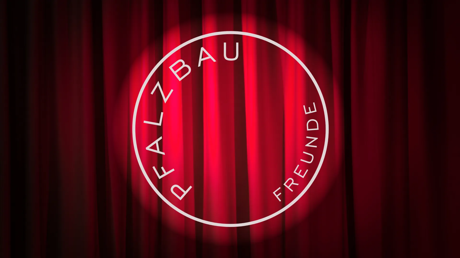 Roter Theatervorhang im Scheinwerferlicht mit dem runden Logo der Pfalzbaufreunde